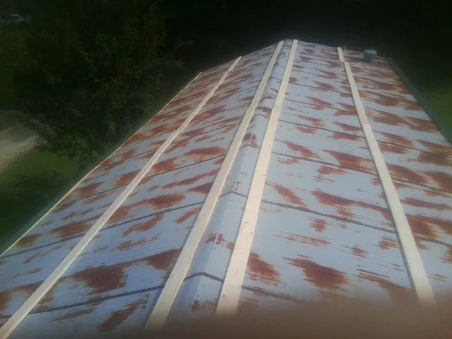 Rusted metal roof panels with new wood purlins before replacement — Storm Damage Roof Repair in Groveton by Roofing Brothers