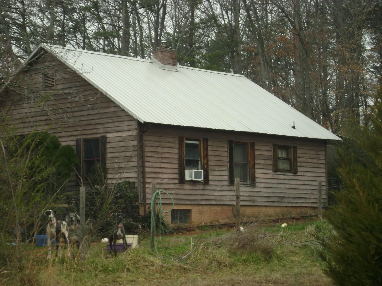 White metal roof on an old wood sided farmhouse, from a Metal Roof Installation job in Groveton